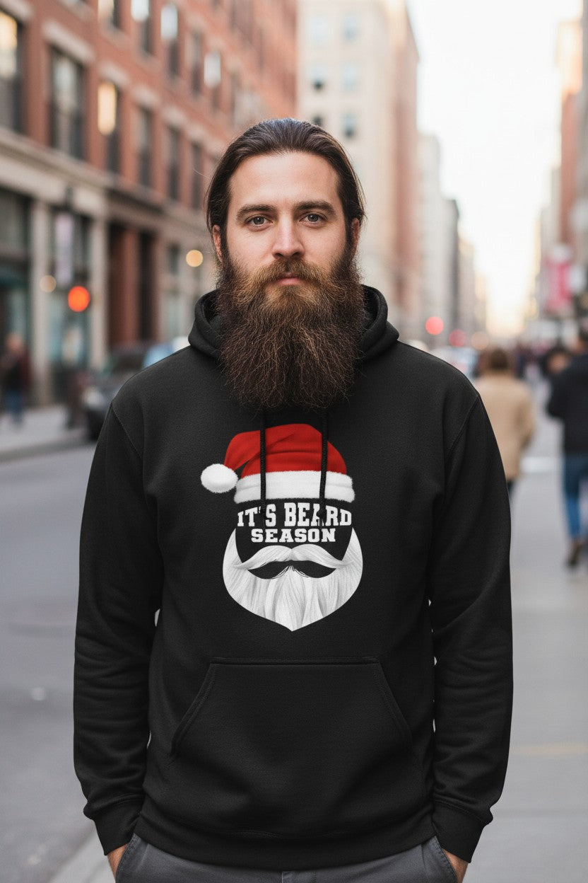 Man wearing It's Beard Season Hoodie with Santa hat design, showcasing festive beard spirit on a city street.
