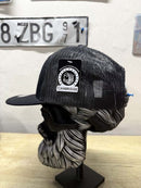 Side view of a black trucker hat with a Cambridge patch displayed on a mannequin with a bearded design.