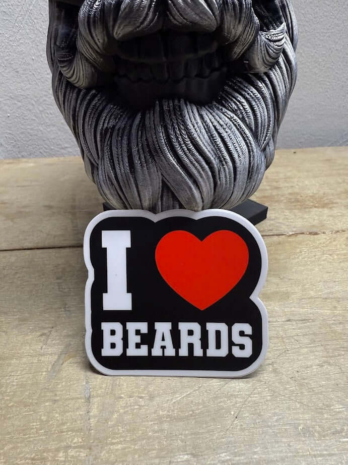 I Love Beards sticker displayed on a wooden surface near a decorative beard sculpture.