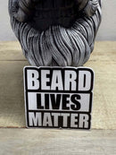 Beard Lives Matter 3-inch sticker on a wooden surface next to a skull figurine, showcasing beard pride in bold black-and-white design.