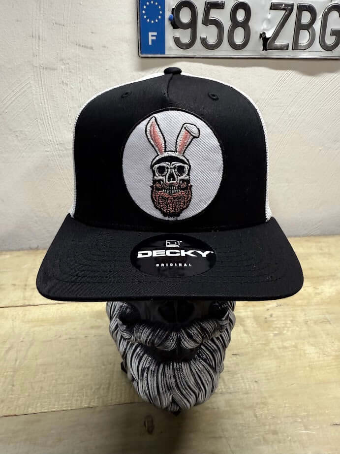 Easter Bunny Beard Guy Trucker Hat featuring playful skull with bunny ears, black and white design, perfect for festive style.