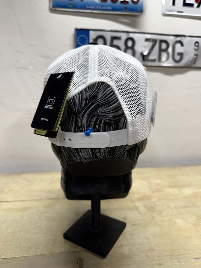 Back view of a white trucker hat with a mesh design and adjustable snap closure on a mannequin head.