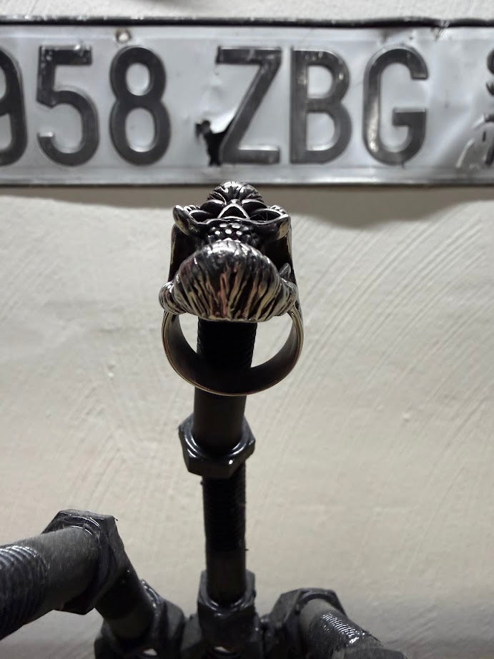 Bearded Skull Guy Men Stainless Steel Heavy Duty Ring displayed on a black holder with a vintage license plate in background.